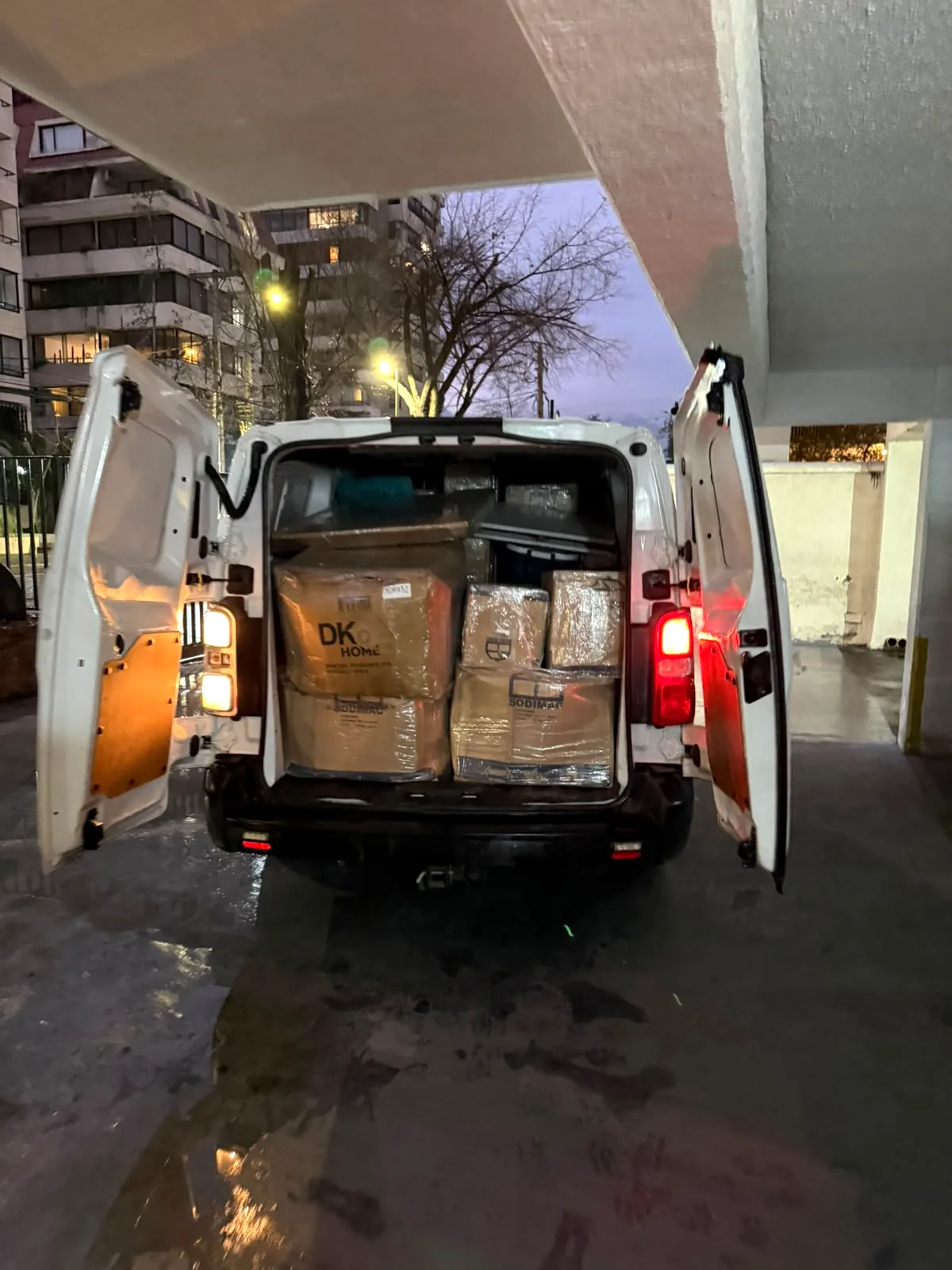 Furgón blanco cargado con cajas embaladas durante despacho en Santiago